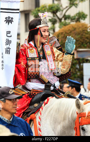 Genji Festival Parade in Japan. In der Nähe der jungen Frau auf dem Pferd, in Samurai Rüstung mit kleinen Heian Ära Krone auf dem Kopf gekleidet, winken zu Gast. Stockfoto