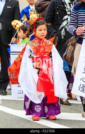 Genji Tada Heiligtum Festival. Parade der Kinder in der Heian-zeit Kostüm. Junge Mädchen, 6-8 Jahre alt, mit Gold Crown, weißes Gewand und roter Jacke. Stockfoto