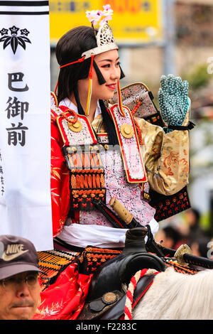 Genji Festival Parade in Japan. In der Nähe der jungen Frau auf dem Pferd, in Samurai Rüstung mit kleinen Heian Ära Krone auf dem Kopf gekleidet, winken zu Gast. Stockfoto