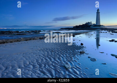 Ebbe auf dem Damm in Richtung St. Marys Leuchtturm, Whitley Bay, England. In der Dämmerung fotografiert. Stockfoto