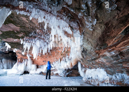 Eine Person, die unter Sandstein Decke eine Eishöhle bei Apostel Island National Lakeshore, Füllhorn, Bayfield County, Wi Stockfoto