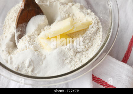 Backzutaten in einer Schüssel mit einem Holzlöffel auf Geschirrtuch Stockfoto