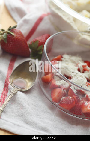 Frische Erdbeeren, zerkleinert und gemischt mit Mehl zum Teig mit einem Maß von Vanille in einem Löffel hinzufügen Stockfoto