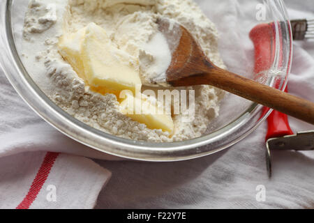 Butter, Mehl und Zucker in einer Schüssel mit einem Holzlöffel, Gebäckmischmaschine auf der Seite Stockfoto