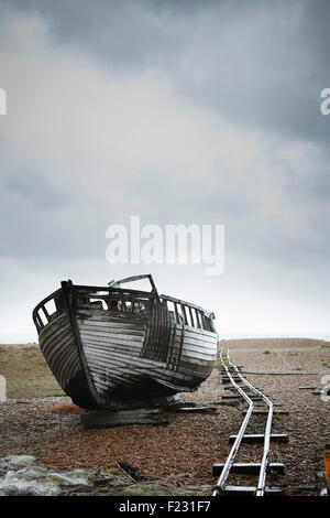 Verlassene Holzboot gestrandet auf dem Kies von einer alten Schmalspurbahn Spur. Stockfoto