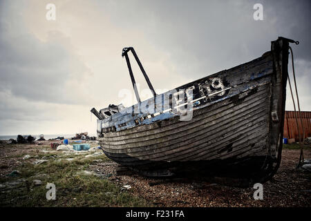 Holzboot auf einem Kiesstrand liegen aufgegeben. Stockfoto