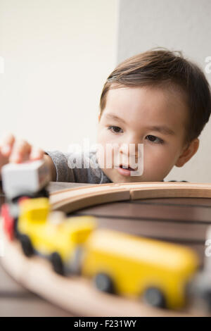 Kleiner Junge spielt mit einer Holzeisenbahn. Stockfoto