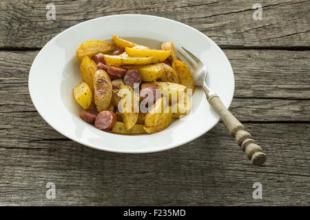 Platte mit erfahrenen Bratkartoffeln und Würstchen Stockfoto