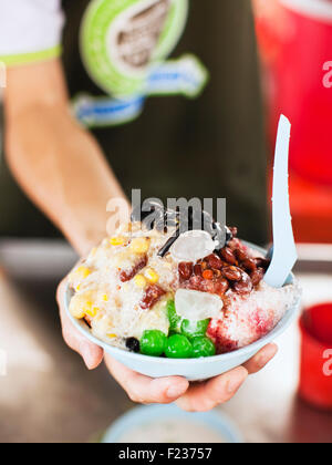 Penang Road berühmte Teochew Chendul Warenkorb.  Übergabe eines Kundens eine Schüssel mit Eis Kacang. Georgetown, Penang, Malaysia. Stockfoto