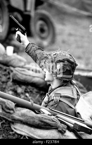 Weltkrieg 11 Soldaten mit einer Pistole schießen die deutschen von einem Bunker auf dem Schlachtfeld Stockfoto