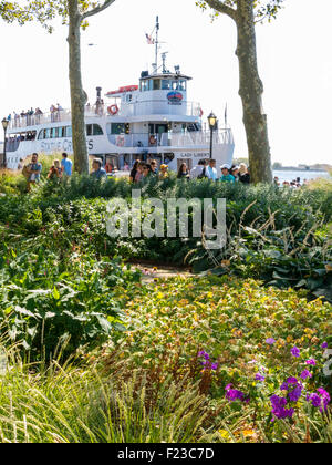 Battery Park mit Freiheitsstatue Fähre im Hintergrund, NYC Stockfoto