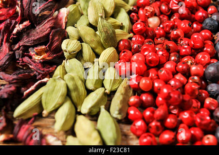 Nahaufnahme von einem Haufen von getrockneten Hibiskusblüten, grüner Kardamom, rosa Pfefferkörner und Wacholderbeeren Stockfoto