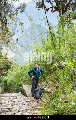 Peru, ruht weibliche Backpacker auf steilen Stein Trail in der Nähe von Sayaqmarka Ruinen entlang Inka-Trail nach Machu Picchu Stockfoto