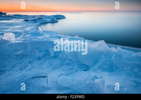 Sonnenaufgang mit rosa Orange Farben in Himmel am Lake Superior im Winter, mit Platte Eis geschoben am Ufer, Kaskaden-Region auf der Nor Stockfoto