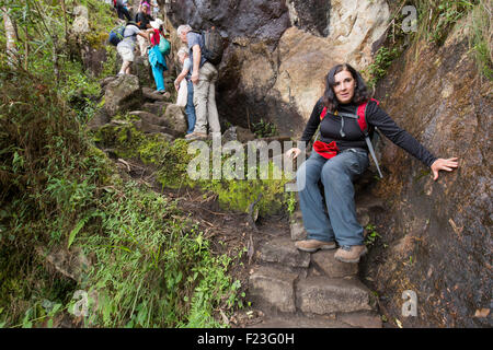 Peru, Urubamba Provinz, Frau gefährlich nach unten wandern steil und nasse Treppen auf Trail bis Huayna Picchu in der Nähe von Machu Picchu Ruinen Stockfoto