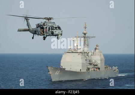 Ein uns Marine HH - 60H Sea Hawk-Hubschrauber durchläuft die Arleigh Burke Klasse geführte Flugkörper Kreuzer USS Normandy während Betrieb innewohnende lösen 9. September 2015 in das Arabische Meer. Die Roosevelt wurde aus Jemen geöffnet Schifffahrtswege während des Bürgerkrieges bewirken das Land versichern positioniert. Stockfoto