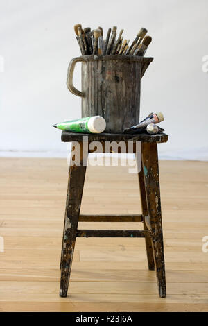 Pinsel und Farben Röhren auf einem Hocker Stockfoto
