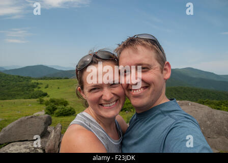 Ein paar Pausen am oberen Rand einen grasbewachsenen Berg, ein Selbstporträt zu nehmen Stockfoto