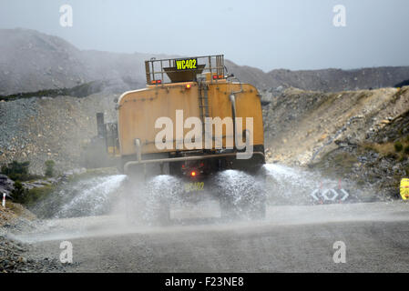 WESTPORT, Neuseeland, 10. März 2015: Gewässer ein Wasser-LKW die Straße um dem Staub am Stockton Tagebau Kohle mir halten Stockfoto