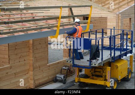 Ein Generator installiert eine Sicherheitsabdeckung auf dem Dach eines neuen Gebäudes, bevor das Eisen weiter geht Stockfoto