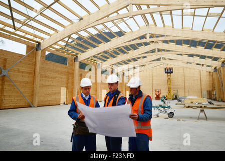 Drei Bauherren diskutieren den Plan für einen großen Bau job Stockfoto