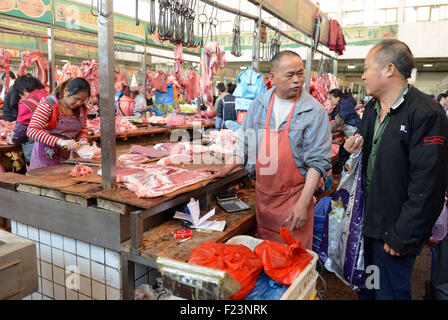 Dongguan, Guangdong, CHN. 1. Januar 2015. Dongguan, CHINA - 1. Januar 2015: (Nur zur redaktionellen Verwendung. CHINA aus) Mastschwein Händler Liu steht auf und geht auf den Markt mit Messern und einer Fackel bei 0:30 Uhr jeden Tag, zusammen mit seiner Assistentin und Schwiegertochter Frau Huang. Dutzende von Schweinen sind verpackt in seinem Stall, später schneidet er vier Beine, Frau Huang entfernt Haare an Beinen Schwein. Wenn Fleisch vom Knochen vollständig geschält ist, wird er eine rauchen, dann das Fleisch in Stücke schneiden. Jedes Stück ist mindestens 10 kg weil Liu ist ein Großhändler. Und seine Acquaintancs kommen, fast dieselben Menge zu holen. Und er endet bu Stockfoto