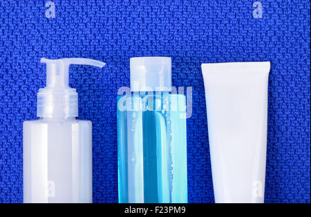 Tägliche Basispflege Kosmetik - Gesicht waschen Reinigungsgel, Glättung, Toner und Creme auf Marineblau Handtuch. Ansicht von oben. Stockfoto