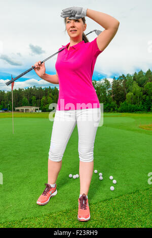 schöne Frau auf einem Golfplatz Blick hinter einem fliegenden ball Stockfoto
