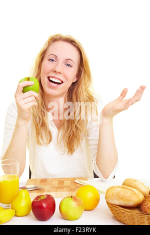 Frau am Frühstückstisch einen Apfel essen Stockfoto