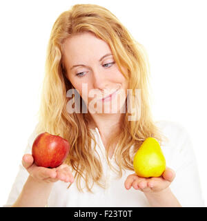 Blonde Frau vergleicht man einen Apfel mit Birne Stockfoto