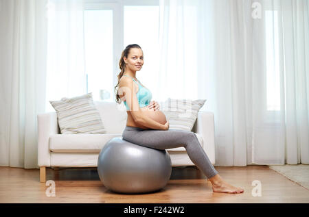 glücklich schwanger Frau auf Fitball zu Hause trainieren Stockfoto