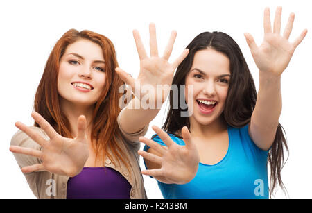 zwei lächelnde Mädchen zeigen ihre Handflächen Stockfoto