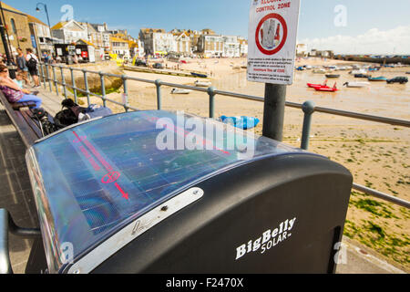 Eine big Belly solar Abfallbehälter an der Promenade in St. Ives, Cornwall, UK. Die solar betriebene bin verdichtet den Müll, so muss es Stockfoto