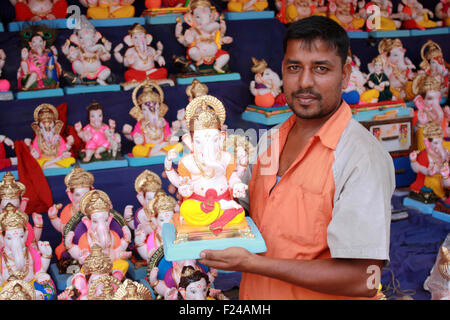 Ein Mann verkauft Lord Ganesh Idole am Vorabend des Ganesh Festival in Indien. Das Festival umfasst Tausende von Besuchern aus allen ove Stockfoto