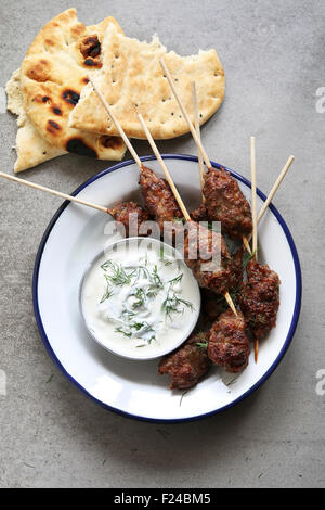 Türkische Kofta auf eine Emaille Teller mit Dill-Joghurt-dressing Stockfoto