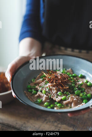 Kastanienmehl Ravioli mit Artischocken, Erbsen, Brühe und Enoki Pilze Strohhalme. Stockfoto