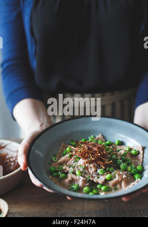 Kastanienmehl Ravioli mit Artischocken, Erbsen, Brühe und Enoki Pilze Strohhalme. Stockfoto