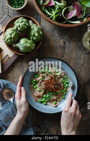 Kastanienmehl Ravioli mit Artischocken, Erbsen, Brühe und Enoki Pilze Strohhalme. Stockfoto