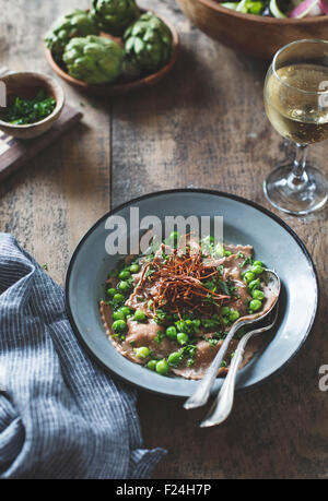 Kastanienmehl Ravioli mit Artischocken, Erbsen, Brühe und Enoki Pilze Strohhalme. Stockfoto