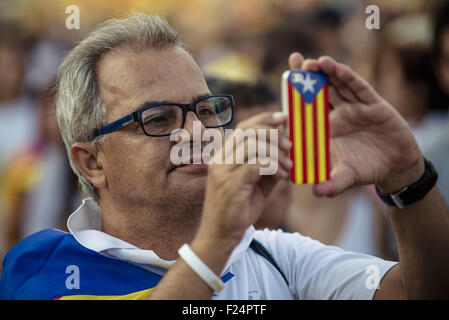 11. September 2015 - katalanische Unabhängigkeit Anhänger nimmt ein Bild mit seinem Handy, bedeckt mit dem katalanischen Farben am Ende der Veranstaltung in Barcelona Meridiana Straße am Nationalfeiertag Kataloniens für die Unabhängigkeit von Spanien © Matthias Oesterle/ZUMA Draht/Alamy Live News Stockfoto