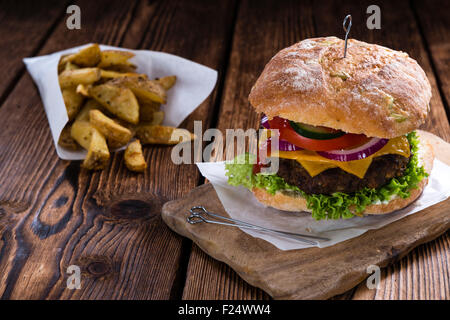 Ciabatta-Burger mit hausgemachten Pommes Frites auf rustikalen Hintergrund Stockfoto