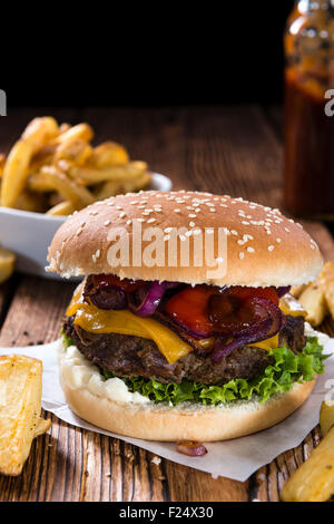 Hausgemachte Burger mit Pommes Frites auf einem alten Holztisch Stockfoto