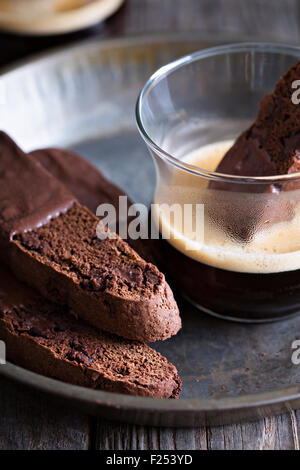 Schoko Kekse Cookies eingetaucht in Schokolade mit einer Tasse Kaffee Stockfoto