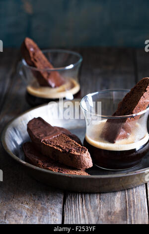 Schoko Kekse Cookies eingetaucht in Schokolade mit einer Tasse Kaffee Stockfoto