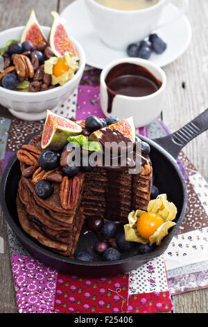 Stapel von Schokolade Pfannkuchen mit Beeren verziert Stockfoto