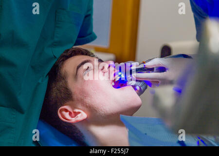 Teenager sitzen im Zahnarztstuhl während er die Klammern Stockfoto