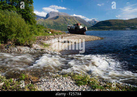 Schiffbruch am Ufer des Loch Linnhe in der Nähe von Fort William in den westlichen Highlands von Schottland zu Ben Nevis im Hintergrund Stockfoto