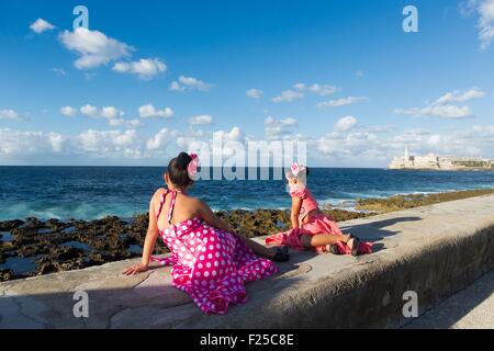 Kuba, Ciudad De La Habana Provinz, La Havanna, junge Mädchen, verkleidet als Flamenco-Tänzer auf dem Malecon und Castillo de Los Tres Reyes Magos del Morro im Hintergrund Stockfoto