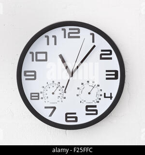 Große schwarze rund um die Uhr auf weißen Wand. Stockfoto