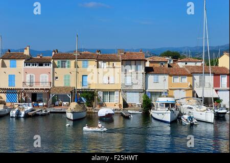 Frankreich, Var, Golf von St Tropez, Port Grimaud Küstenstadt, Häuser mit privaten Steg und das alte Dorf Grimaud im Hintergrund Stockfoto